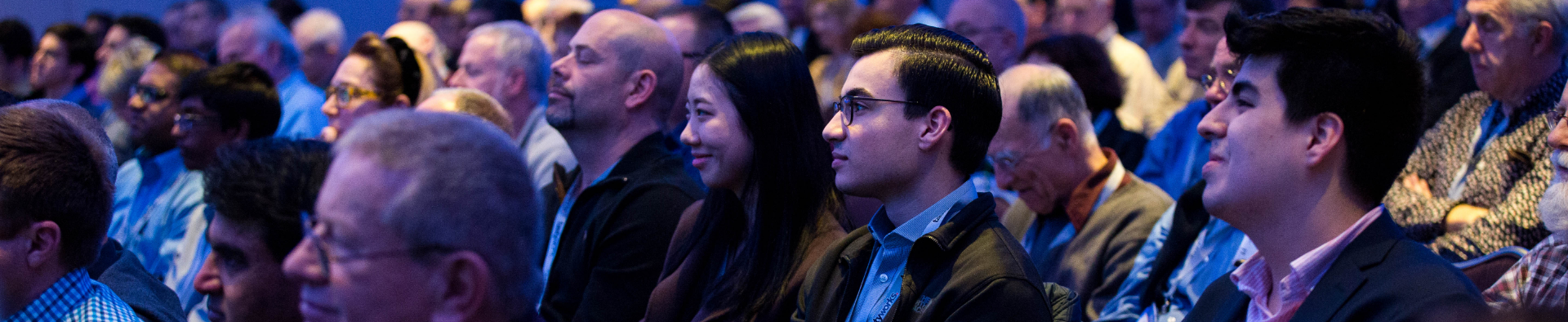 A large image of attendee's watching events at the conference